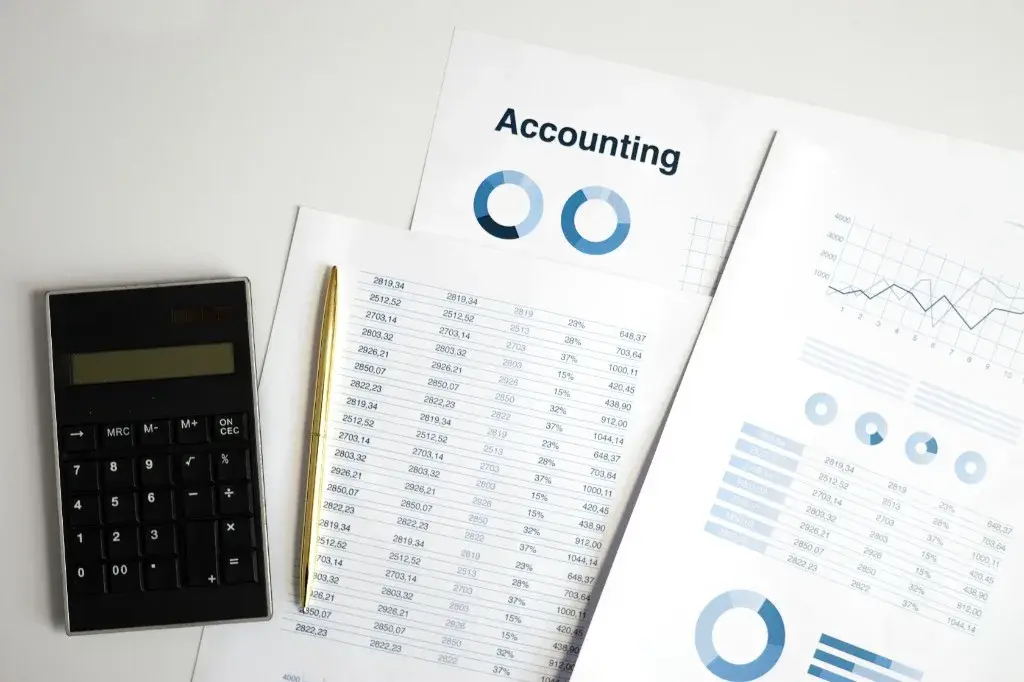 Accounting reports, calculator and financial charts used in equity valuation analysis